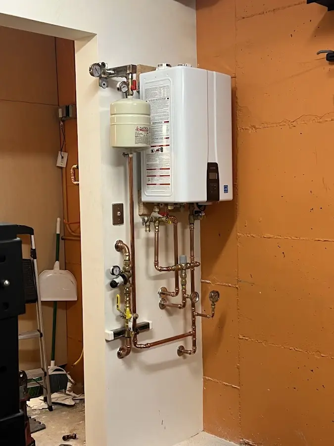 Plumbing technician inspecting water heater connections in Hoover